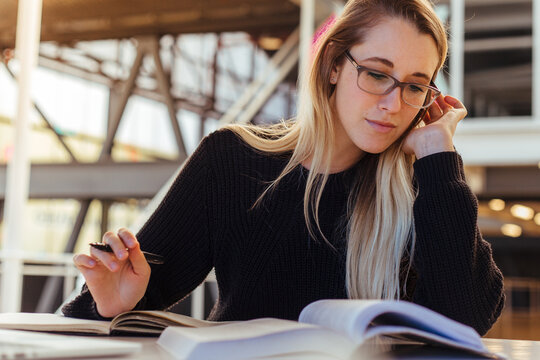 Focused woman studying at desk in university library