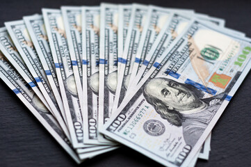 money on the table, black background, US dollars, 100 banknotes, banknotes close-up, cash in the...