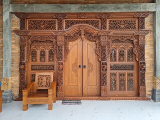 Javanese teak carved door.  In Java it is known as the gebyok door.  traditional wooden door - obrazy, fototapety, plakaty