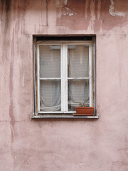 Obraz na płótnie Canvas Window with wooden shutters, neutral pink wall. Traditional European old town building. Old ancient historic architecture