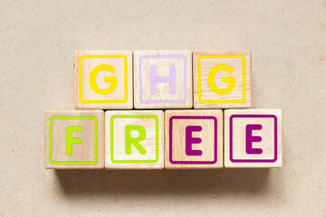 Color letter block in word GHG (Abbreviation of greenhouse gas) free on wood background