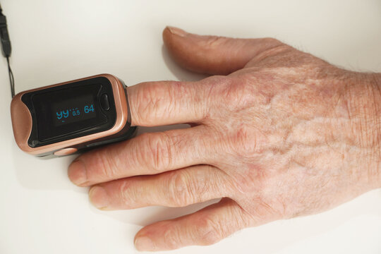 Senior man use pulse oximeter to measure  blood oxygen saturation. Checking health condition. Coronavirus pandemic.