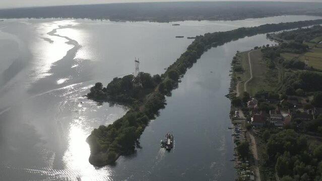 Ferry boat on Danube river in the sunset - It approaches the coast through the DTD channel.