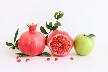 Rosh hashanah (jewish New Year holiday) concept. Pomegranate and apple traditional symbol over white background