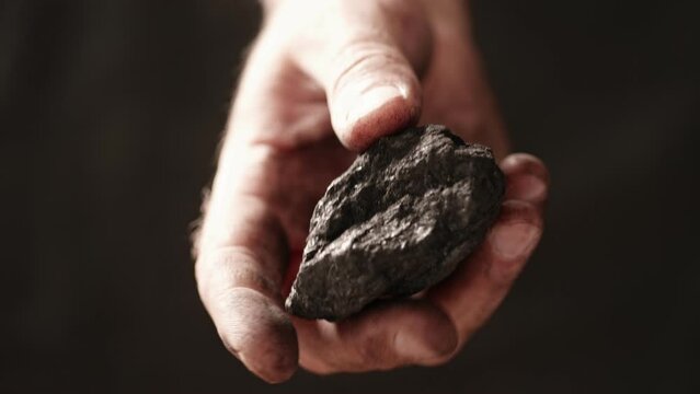 A lump of coal in a miner's hand.