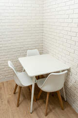 White brick wall with table in corner of kitchen