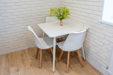 Green plant in vase on table with white brick wall