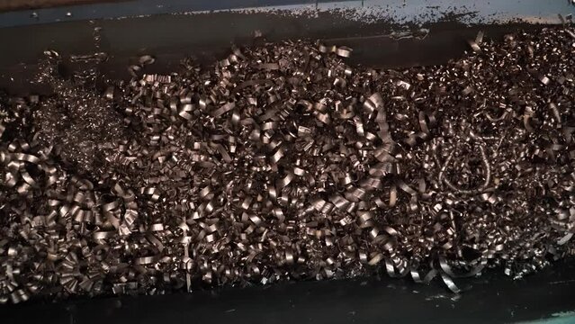 Steel Scrap Moving Scrap Conveyor Lathe Machine,Steel scrap materials recycling. Aluminum chip waste after machining metal parts on a cnc lathe. Closeup twisted spiral steel shavings. Small roughness