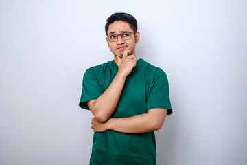 Asian male doctor in scrubs looking thinking, searching for solution