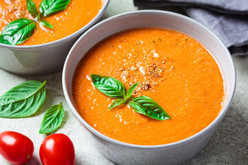 Traditional gaspacho in gray bowl. Summer tomato soup with basil.