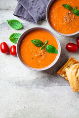 Traditional gaspacho in gray bowl. Summer tomato soup with basil.