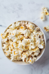 Blurred popcorn bowl background, defocus concept, top view. Snack for movie.