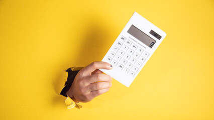 male hand calculator a yellow background - obrazy, fototapety, plakaty