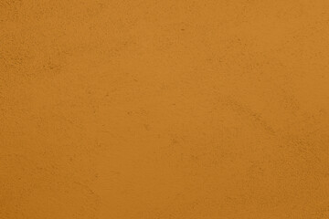 Saturated pastel yellowish brown colored low contrast Concrete textured background. Empty colorful wall texture with copy space for text overlay and mockups. 2023, 2024 color trend