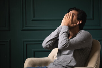 Obraz premium sad man sitting in armchair