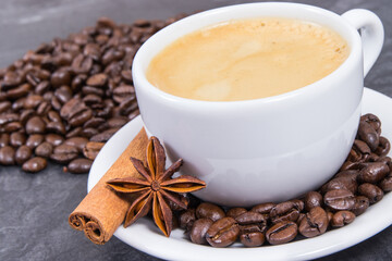 Coffee in cup and roasted dark coffee beans with anise and cinnamon