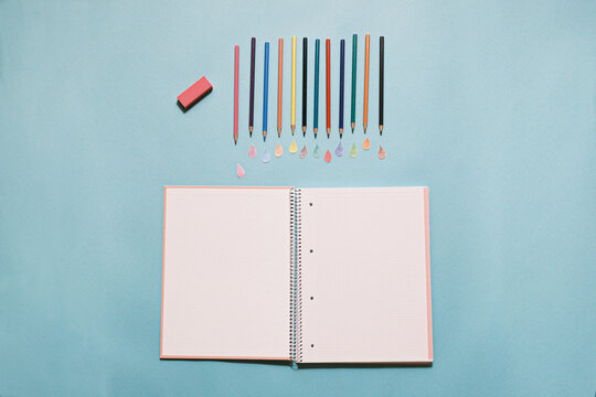 Back to school: new notebook, pencils with drops of color and eraser