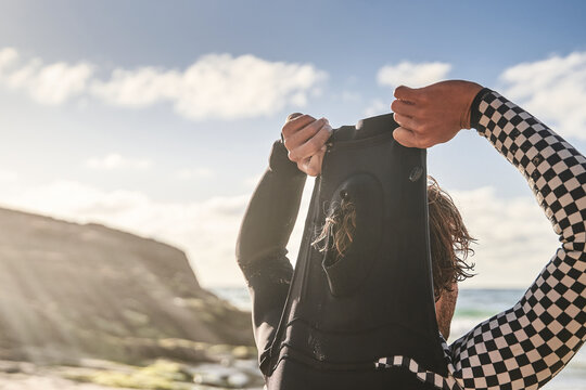 Unshaven male surfer wearing his wetsuit and looking at the ocean