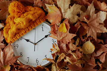 autumn background with clock, hat and leaves