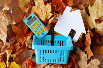 autumn background with calculator and consumer basket - obrazy, fototapety, plakaty