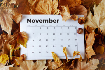 autumn background with November calendar and leaves - obrazy, fototapety, plakaty