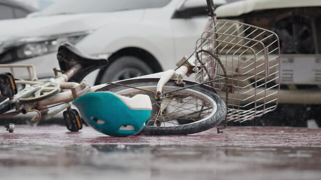 Bicycle helmet spinning and falling down bicycle on the road after traffic accident on a raining day