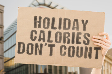 The phrase " holiday calories don't count " is on a banner in men's hands with blurred background. Worry. Issue. Trouble. Difficulty. Difficult. Anxiety. Failure. Preparation. Overeating. Energy