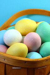 Easter eggs painted with pastel colours in basket 