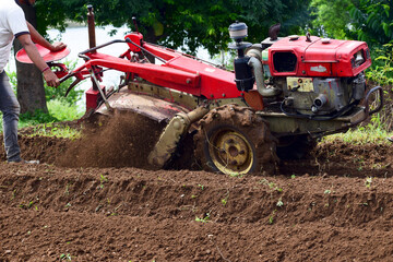 Obraz premium Farmers cultivate land with tractor or power tiller machine, modern agriculture, tractor