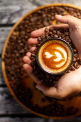 coffee latte art with male hand on roasted coffee beans