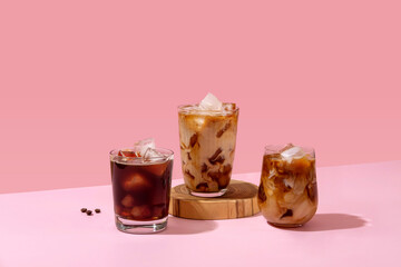 Ice coffee in a tall glass with cream poured over and coffee beans. Set with different types of...