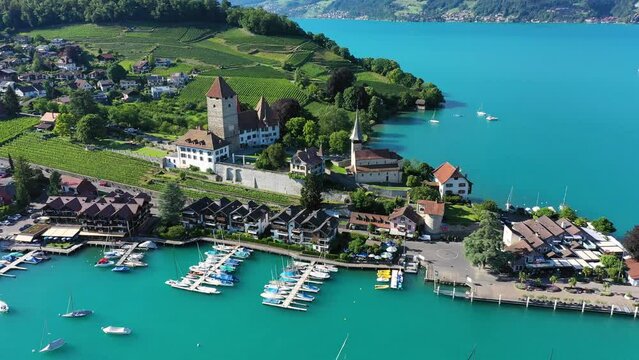 Aerial panoramic view of Spiez Church and Castle on the shore of Lake Thun in the Swiss canton of Bern at sunset, Spiez, Switzerland. Spiez Castle on lake Thun in the canton of Bern, Switzerland.