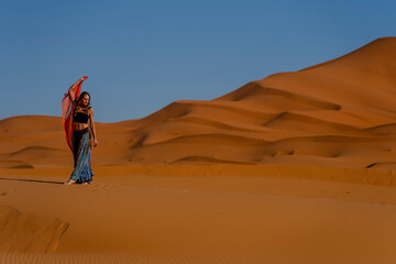 A Beautiful Model Poses In The Sand Dunes In The Great Sahara Desert In Morocco, Africa - obrazy, fototapety, plakaty