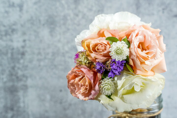 Bouquet of colorful flowers placed in an ice cream cone. Gray background. Still life image. Space for text.