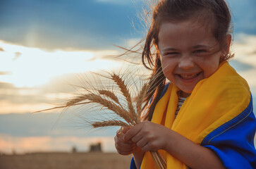 Child with Ukrainian flag. Girl with wheat in her hands. War in Ukraine. Wheat in children's hands. A child with a blue and yellow flag in the field. Export of Ukrainian grain. Peace concept. freedom