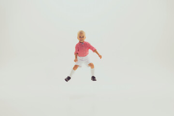 Fototapeta na wymiar Portrait of little smiling boy, child in pink checkered shirt playing, posing, having fun isolated over grey studio background