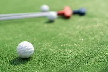 Close-up of miniature golf hole with bat and ball