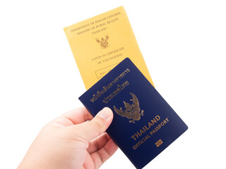 Hand holding Thailand official passport and vaccine passport are on isolated white background with a clipping path.