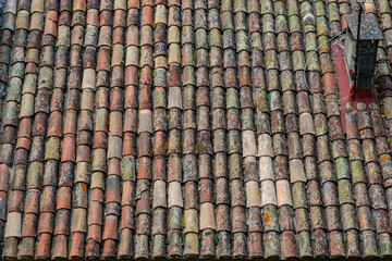 Lichen covered provence clay roof tiles close up