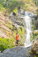 Young tourist standing in front of vibhooti water falls