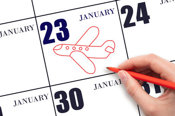 23rd day of January. A hand drawing outline of airplane on calendar date 23 January. The date of flight on plane. Travel, business trips. Winter month. Day of the year