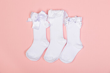 high white children's socks for girls with big bows for party wear on a pink background