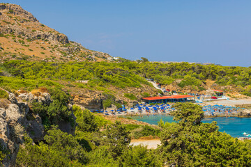 Fototapeta na wymiar Beautiful view of hotel's beach area on coast of island in bay of Mediterranean sea. Rhodes. Greece.
