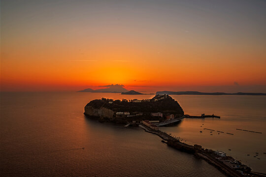 the small island of Nisida in Naples photographed a few minutes after sunset, during the golden hour. In the background the islands of Ischia and Procida