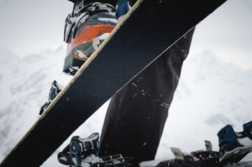 Close-up of a man's hand, adjusting the skis against the background of snow and things, putting on...