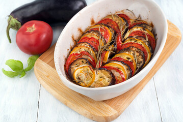 Cooked ratatouille in the foreground, vegetables in the background.