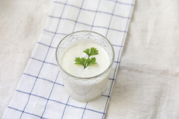 A glass of ayran on a light background linen towel