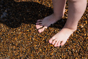 Children's feet close-up on the seashore. High quality photo