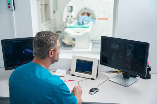 Doctor Works With An Injector To Induce Contrast