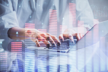 Double exposure of woman hands typing on computer and forex chart hologram drawing. Stock market invest concept.